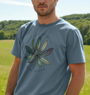 A Man Dressed In a Blue T-shirt Adorned With a Leaf Design, Nature's Promise Men's Organic T-shirt Collection.