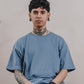 A Tattooed Man Sitting On A Chair, Wearing A Men's Oversized Organic T-shirt