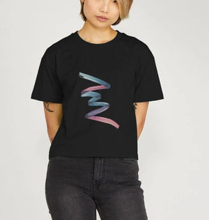 A woman in a black t-shirt featuring a pink and blue watercolor design, showcasing the Colour Twist Women's Boxy Fit style.