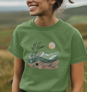 A woman in a green t-shirt featuring a bird and sun design