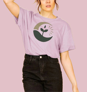 A woman in a pink t-shirt featuring a green plant design, showcasing the sunrise sprout women's relax fit organic t-shirt