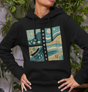 A woman models a black hoodie with a wave and blue sky design