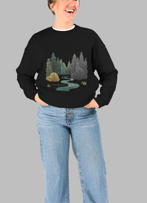 A woman models a black organic sweatshirt with a forest graphic,