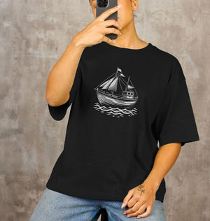 A woman models a black oversized t-shirt with a boat print